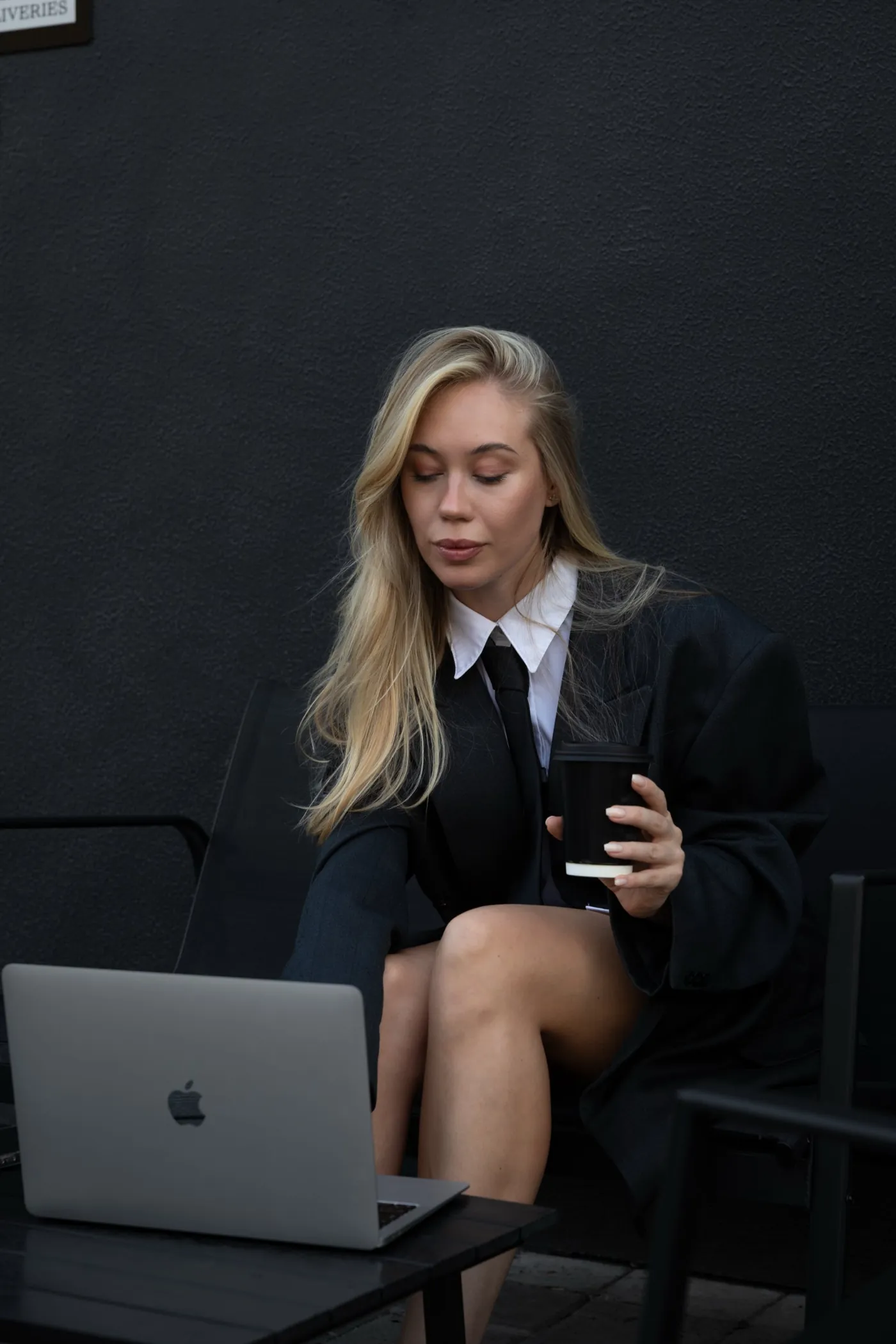 Kamilla working on a laptop with a coffee