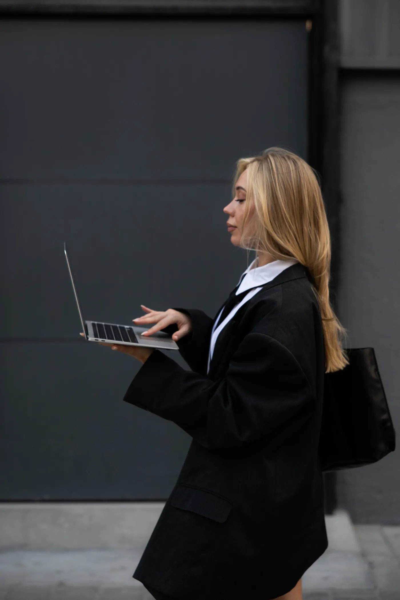 Kamilla in profile holding a laptop